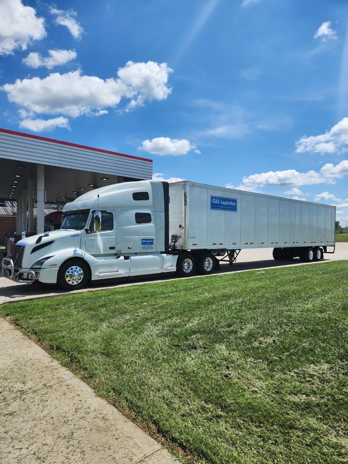A C & E Logistics tractor and branded dry van trailer fueling on a summer run.